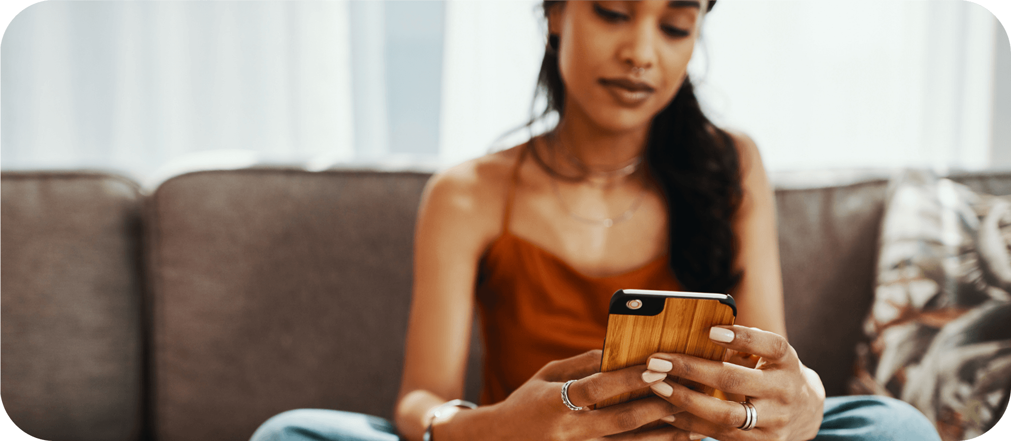 Woman on a couch checking her phone